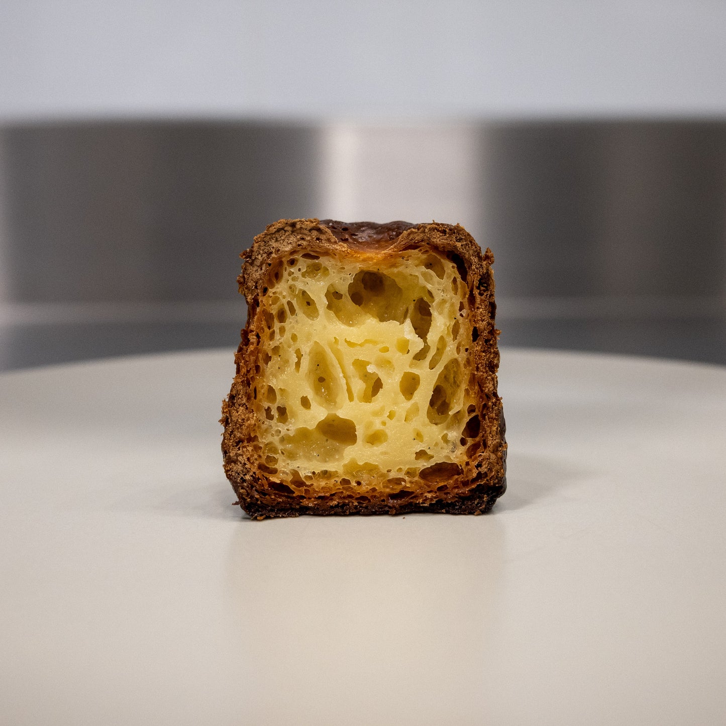 A close-up of the inside of a canelé pastry, showing the custard-like texture and caramelized sugar.